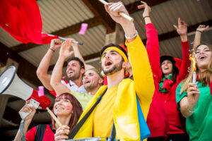 Football supporters at the stadium - Football fans having fun and looking at football match